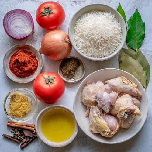مكونات كبسة الدجاج أرز بسمتي دجاج بصل طماطم وبهارات صحيحة
